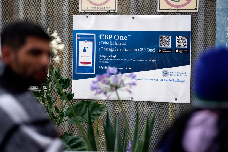 لافتة تعلن عن تطبيق CBP One للهاتف المحمول أثناء مرور طالبي اللجوء.