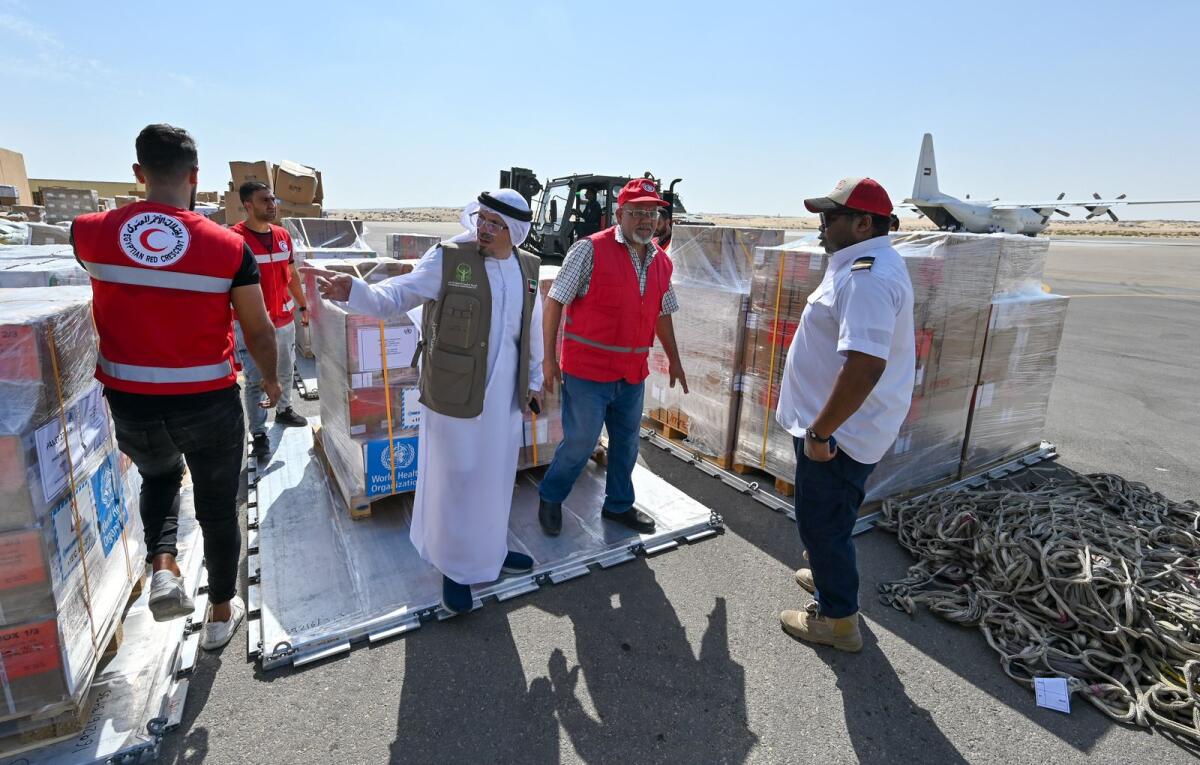 مسؤولون يتفقدون الإمدادات الغذائية والطبية التي تم تفريغها في قاعدة العريش الجوية في مصر.