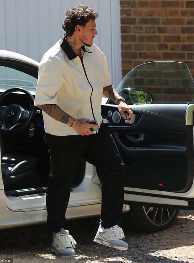 شوهد JJ لاحقًا وهو يرتدي سترة بيضاء وسوداء أثناء خروجه من سيارته الرياضية خارج منزل كاتي