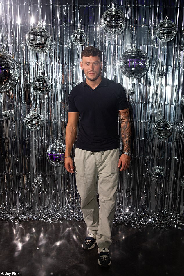 اختار جيك سبيفي قميص بولو أسود وبنطلونًا رماديًا