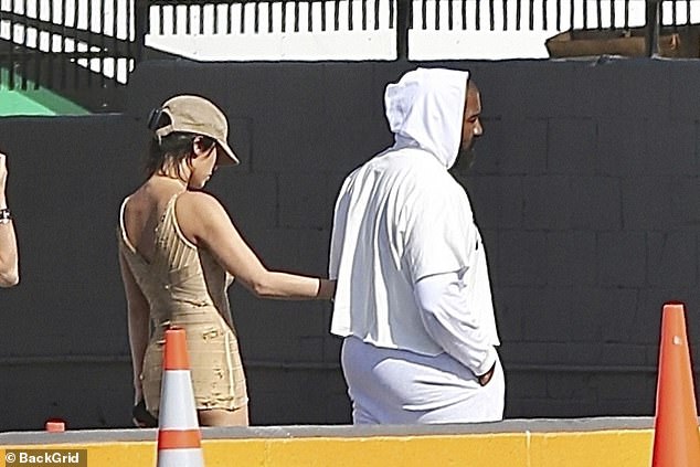 ارتدت موظفة Yeezy السابقة قبعة متطابقة فوق شعرها الداكن وحملت هاتفها في يد واحدة