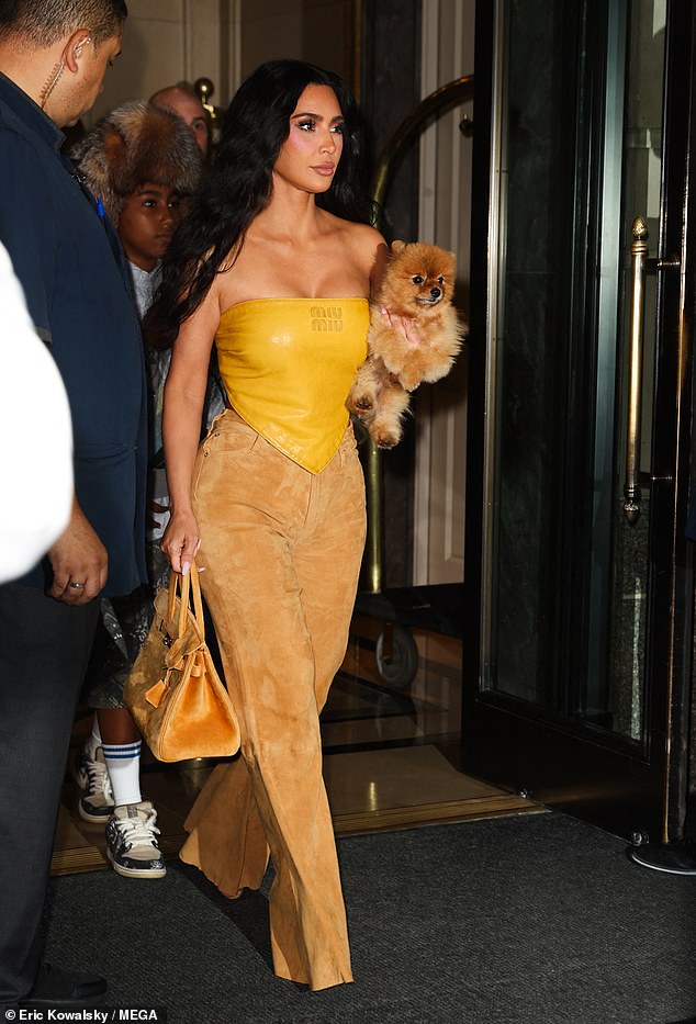 لفتت كيم الأنظار بقميصها المنديل بدون حمالات من MiuMiu والذي نسقته مع بنطلون من الجلد المدبوغ