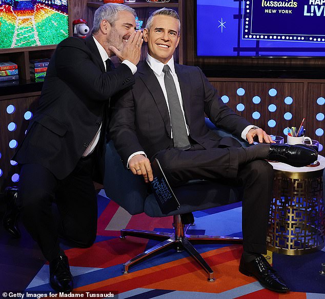 ولتوضيح التمييز، نهض آندي من كرسيه وجلس القرفصاء بجوار تمثال الشمع الخاص به، متظاهرًا بأنه يهمس في أذنه ببعض النميمة.