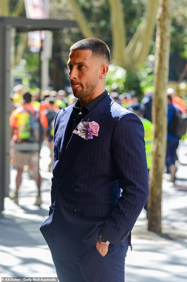 أكمل المجموعة بحذاء جلدي أسود مصقول ووشاح أنيق مزين بالزهور مثبت على صدره، مما أضاف لمسة من الأناقة إلى مظهره الأنيق.