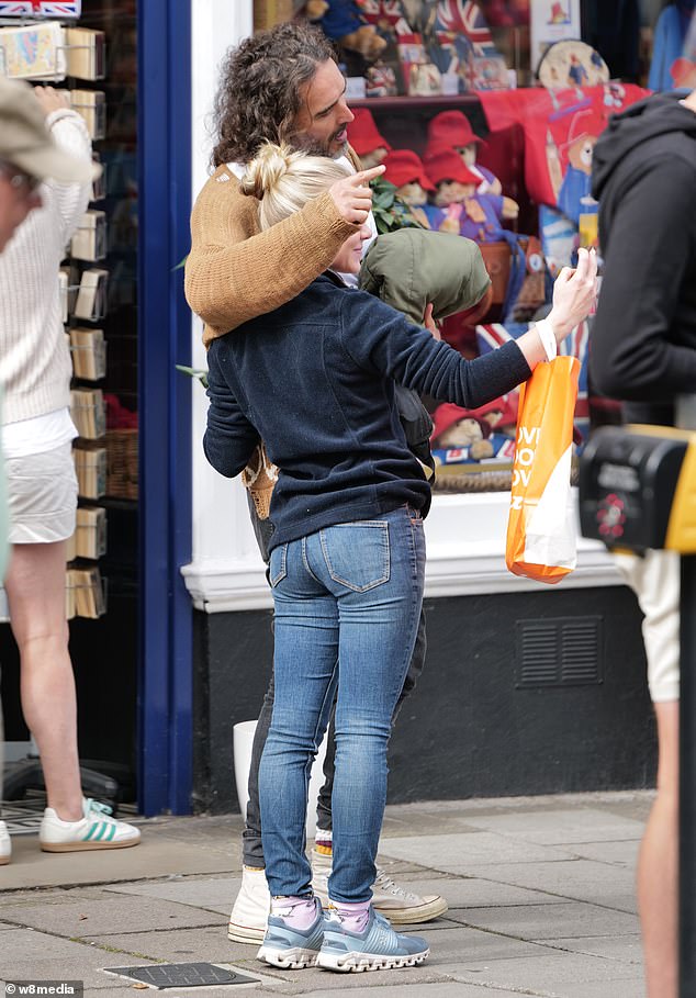 لف راسل ذراعه حول أحد المعجبين بينما كانا يبتسمان لالتقاط صورة