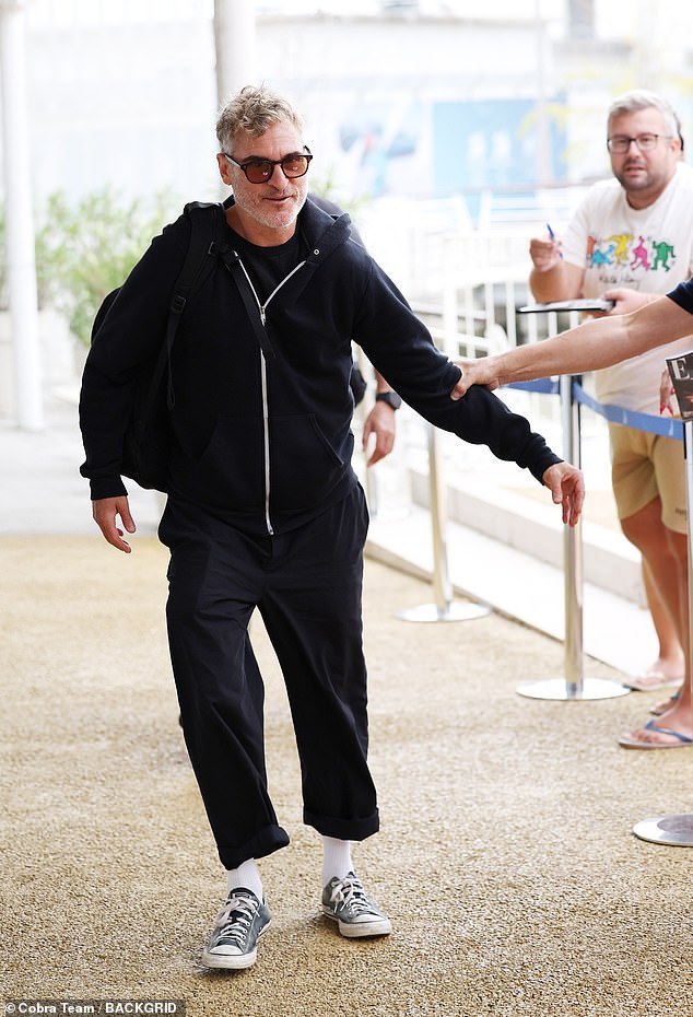 بدا خواكين مرتاحًا في هودي أسود بسحاب أثناء تحية المعجبين وتوقيع التوقيعات