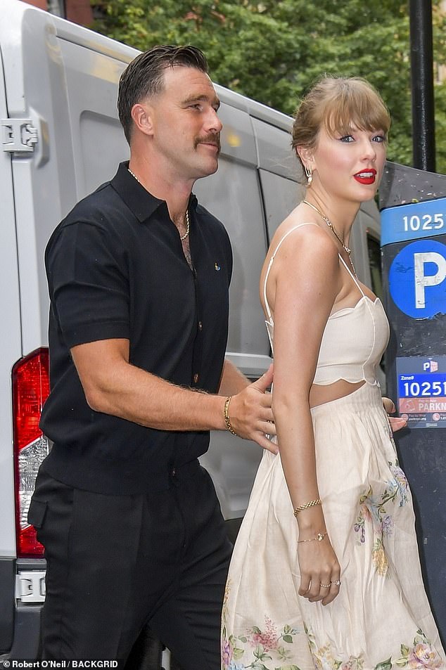 تم تصفيف شعر ترافيس الداكن بعناية في جزء جانبي أنيق