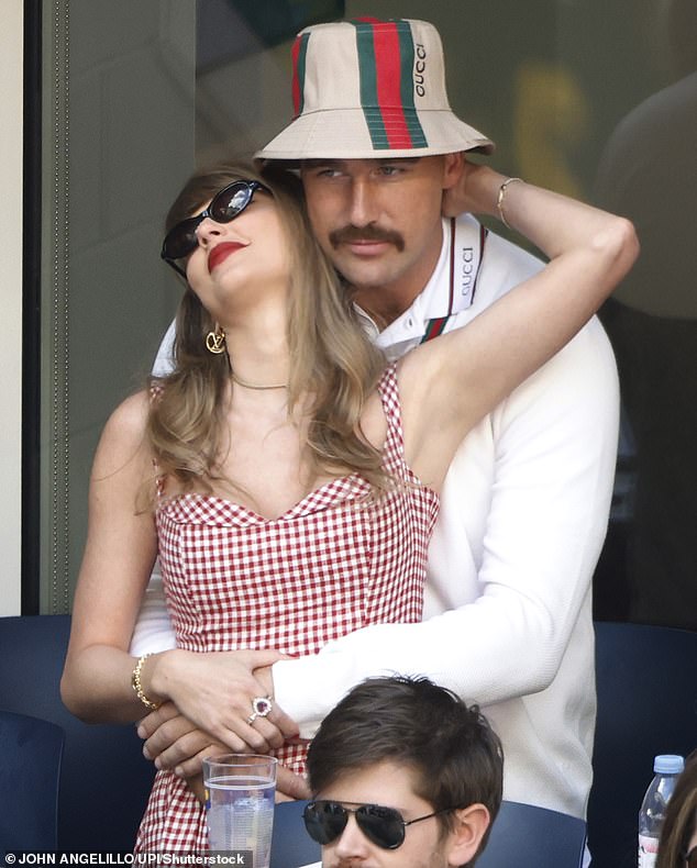 عانقت تايلور حبيبها - الذي كان يرتدي قميصًا أبيض مخططًا مع قبعة دلو