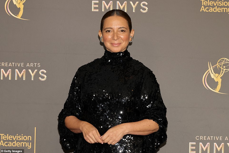 أيقونة SNL مايا، 52 عامًا، تتألق بفستان أسود لامع طويل