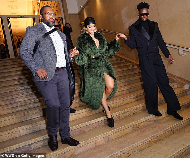 تم مساعدتها على النزول على الدرج بكعبها الضخم