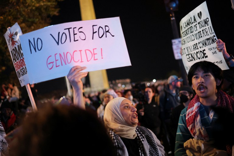 متظاهر مؤيد للفلسطينيين يرفع لافتة مكتوبة بخط اليد تقول: "لا للتصويت للإبادة الجماعية".