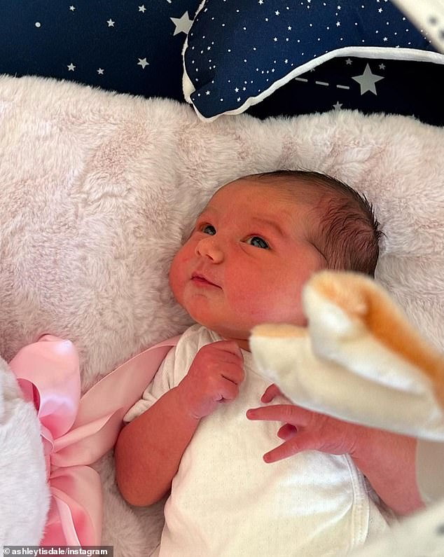 التقطت صورة مقربة للفتاة الصغيرة مستيقظة ونابضة بالحياة وهي تسترخي في السرير