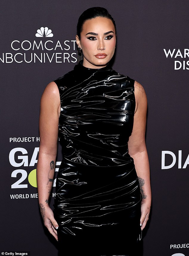 انزلقت ديمي منحنياتها التي تحسد عليها في فستان PVC بلا أكمام مع خط عنق وهمي أنيق