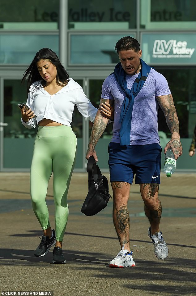 أمسكت صديقته الجديدة بذراعه بمودة بينما كانتا في طريقهما إلى صالة الألعاب الرياضية المحلية