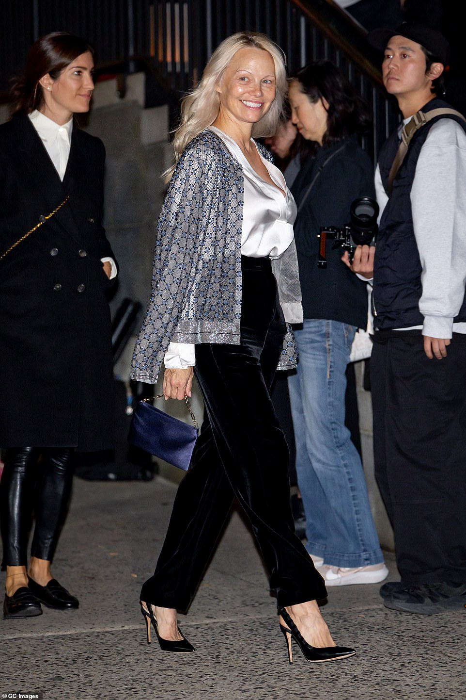 أكملت إطلالتها بحذاء بكعب عالٍ وحقيبة يد من الساتان الأزرق مع حزام مطرز