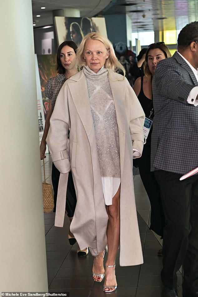 وبدت باميلا (57 عاما) مذهلة في معطف أبيض أنيق فوق سترة لامعة وقميص أبيض