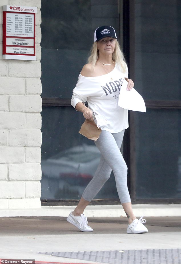 بدت هيذر أنيقة وصحية في طماق رمادية وسترة بيضاء وأحذية رياضية