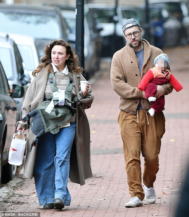 بدا الطفل الصغير مريحًا أثناء الرحلة، ملتفًا حول الجو البارد سواء كان يرتدي بدلة عربة أطفال حمراء ناعمة وقبعة مخططة باللون الأزرق