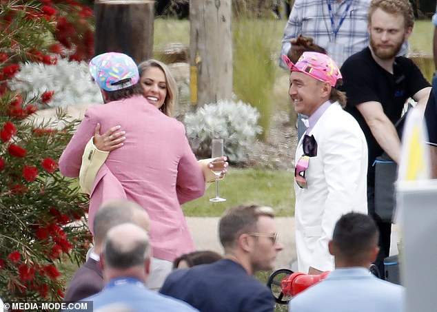 في هذه الأثناء، أبقى ريكي الأشياء مفعمة بالحيوية في سترة وردية فوق قميص أزرق فاتح، متناسق مع بنطال أبيض، وربطة عنق زرقاء مخضرة، وقبعته الملونة من وقت سابق.