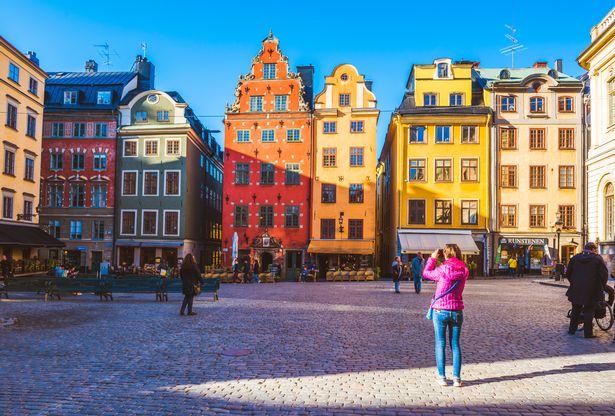 سياحي يصور البولدينغز الأيقونية في Stortorget