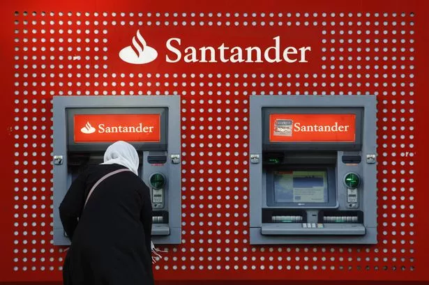 يستخدم العميل آلة صراف آلية (ATM) في Banco Santander