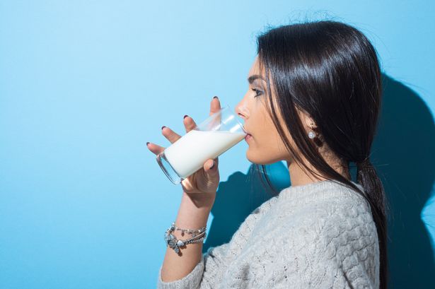 شابات شرب الحليب على خلفية زرقاء