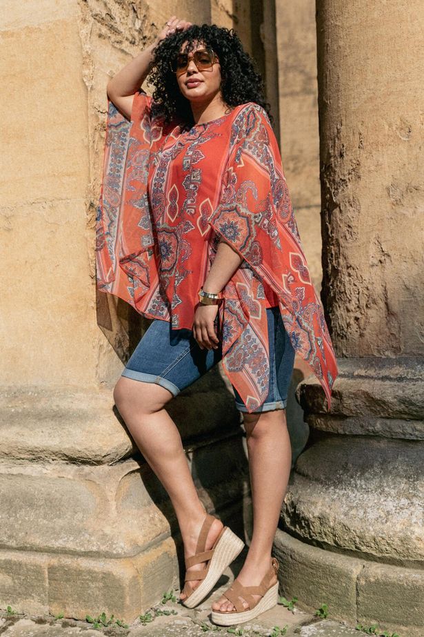 شخص يرتدي منحنى أحمر Ikat Paisley أعلى تراكب غير متماثل