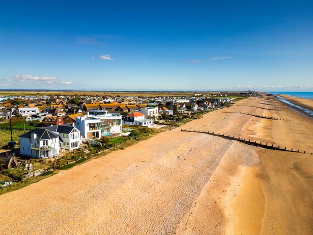 Aerial Drone View التي تصور المنازل الحصرية والفاخرة على شاطئ البحر في Camber Sands في East Sussex ، المملكة المتحدة.