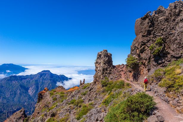 امرأة تمشي على ممر المشاة رقم E7 ، من Pico de la Nieve إلى Roque de Los Mustachos ، في حديقة Caldera de Taburiente الوطنية