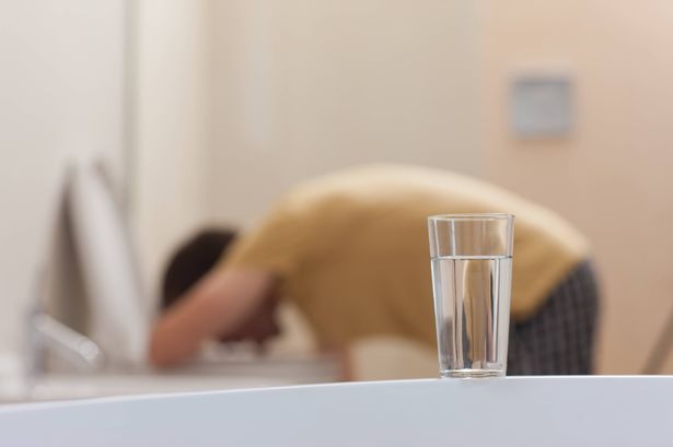 كوب من الأدوية الذائبة مع الرجل القيء في الخلفية