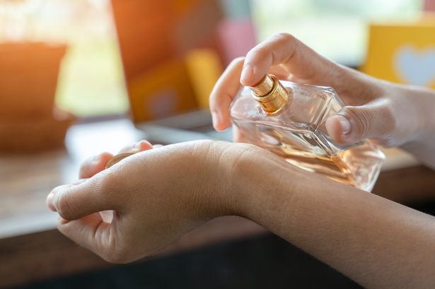 شخص يرش العطر على الرسغ
