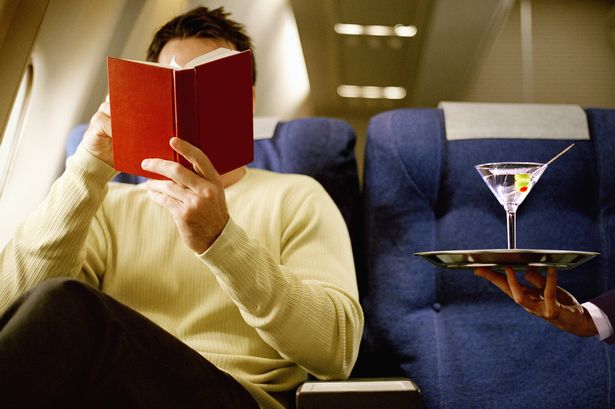 كتاب قراءة رجل ، يجري خدم مارتيني ، في الدرجة الأولى على طائرة