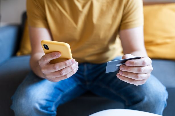 عن قرب من أيدي الذكور تحمل بطاقة ائتمان وهاتف محمول لمعاملة عبر الإنترنت