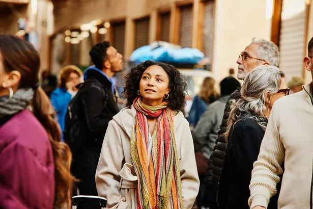لقطة متوسطة للمسافر منفردة معجبة بالهندسة المعمارية أثناء سير المشي في المدينة المنورة في مراكش خلال إجازة في المغرب