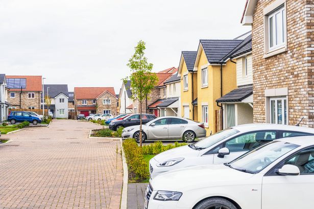 EAST CALDER ، المملكة المتحدة - السيارات متوقفة في الممرات الأمامية للمنازل التي تم بناؤها حديثًا في Calderwood Development.