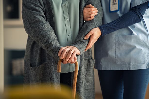 عن قرب يد طبيب مقدم الرعاية مساعدة المرأة العجوز في عيادة خاصة