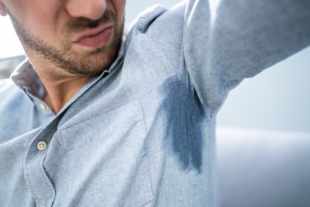 شخص مع بقع عرق على قميصه