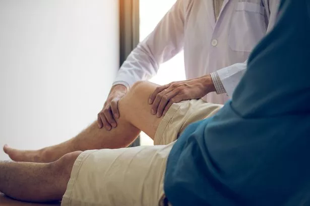 يستخدم المعالجون الطبيعيون مقبض ركبة المريض للتحقق من الألم.