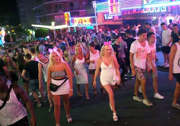 يتجهز السياح في شارع بونتا بالينا في منتجع ماجالوف العيد في كالفيا في جزيرة مايوركا الإسبانية في 19 يوليو 2014. المعروف بين بعض السياح باسم شاغالوف ، عانى المنتجع بشكل خاص الصحافة السيئة على مدار الـ 12 شهرًا الماضية بعد مقطع فيديو يظهر فتاة مراهقة في الشمال الأيرلندية تؤدي أعمالًا جنسية على مجموعة من الرجال خلال فترة زحف في الصيف الماضي. تقدر أن مليون بريطاني يزورون المنطقة كل عام ، حيث يجلب 800 مليون يورو (866 مليون دولار) للاقتصاد المحلي ، لكن المجلس يائس لتحسين سمعة المقصد ، حسبما ذكرت مجلة بريطانيا The Guardian. AFP Photo / Jaime Reina (يجب أن يقرأ ائتمان الصورة Jaime Reina / AFP عبر Getty Images)