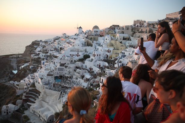 Topshot - ينتظر السياح غروب الشمس في قرية OIA في جزيرة Santorini اليونانية في 20 يوليو 2024. مثل الوجهات السياحية الشهيرة الأخرى ، فإن جزيرة Cycladic التي تطفو على بركان تقترب من التشبع المفرط ، وتريد الآن تقييد عدد من سفن الرحلات البحرية. (تصوير Aris Oikonomou / AFP) (تصوير Aris Oikonomou / AFP عبر Getty Images)