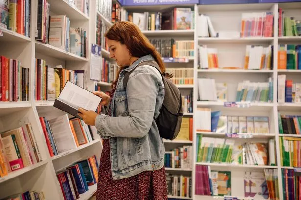 امرأة قراءة كتاب في مكتبة