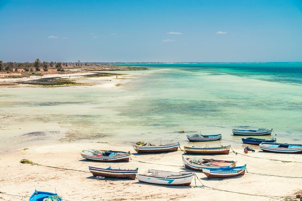 Djerba ، تونس - 3 مايو 2022: DJERBA ، أكبر جزيرة في شمال إفريقيا ، هي جوهرة تونسية تقع في خليج جابس. يشتهر بشواطئها الرملية البيضاء والمنازل المميزة المميتة ، وهي توفر مشهدًا هادئًا مع ظلال متعددة من البحار الفيروزية. يحافظ شعب جربان ، المتميز ثقافياً عن تونلاند تونسيون ، على العديد من تقاليدهم الفريدة والهندسة المعمارية. في عام 2023 ، تم تعيين Djerba موقع التراث العالمي لليونسكو ، معترفًا بتاريخه الغني.