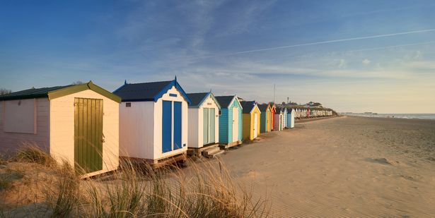 الفجر على ساحل Suffolk Heritage of Southwold. لقد كسرت الشمس الأفق للتو ، وألقيت توهجًا دافئًا على أكواخ الشاطئ الخشبية الملونة التي تتناقص في المسافة نحو الرصيف الجنوبي في الأفق.