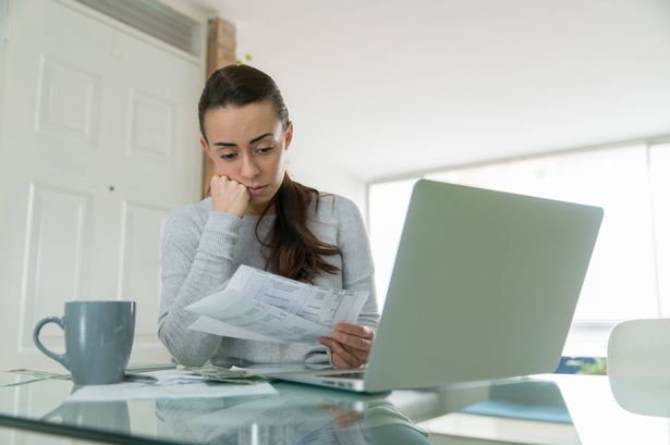 امرأة تدفع فواتير المرافق الخاصة بها عبر الإنترنت وتبدو قلقة أثناء الإقامة في المنزل خلال الوباء - مفاهيم المالية المنزلية