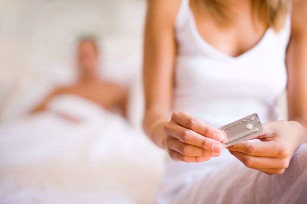 وسائل منع الحمل في حالات الطوارئ. امرأة تأخذ حبة منع الحمل. شريكها وراءها.