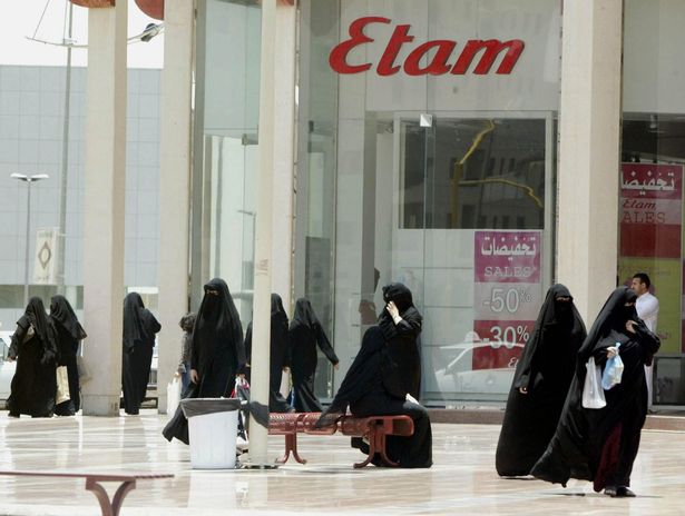 تسير النساء خارج مركز تجاري في الرياض 