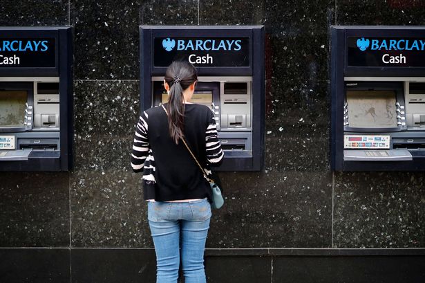 يستخدم العميل آلة ATM خارج فرع من بنك باركليز 