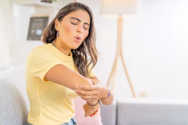 امرأة شابة مع ألم الكوع
