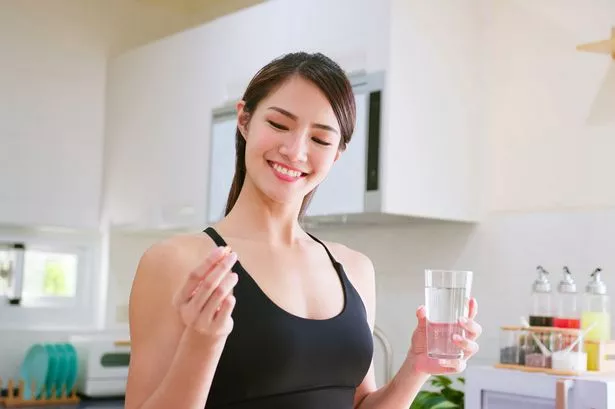 امرأة مع ماء وحبوب منع الحمل