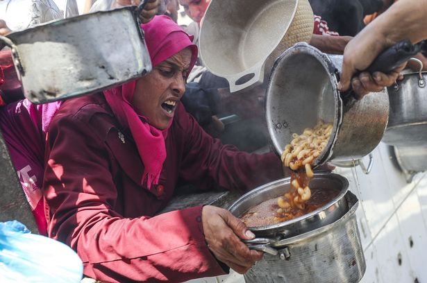 جاباليا ، غزة - 7 مايو: ينتظر الفلسطينيون النازحون ، بمن فيهم الأطفال ، مع الأواني الفارغة لتلقي الطعام الموزعة من قبل المنظمات الإنسانية في معسكر جاباليا للاجئين في قطاع غزة الشمالي في 7 مايو 2025.